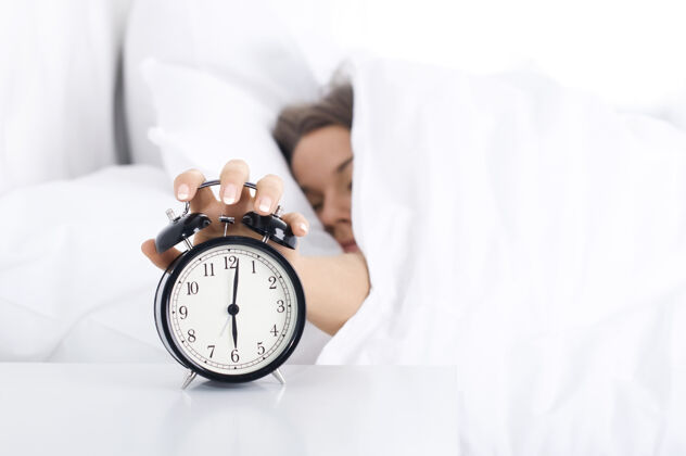 钟女人关掉闹钟明亮健康的生活方式睡眠
