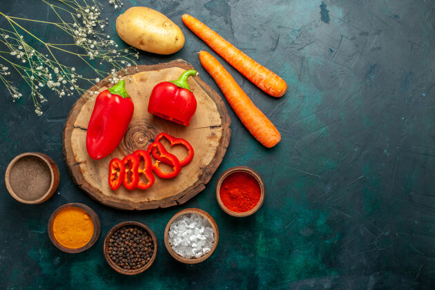 美食顶视图红甜椒用不同的调味料放在深绿色的蔬菜表面辛辣辣的食物午餐盘子蔬菜