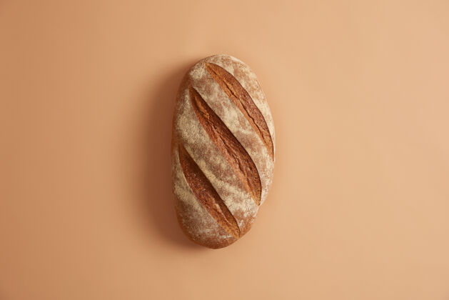 硬皮新鲜出炉的自制长面包 以米色为背景不同的配料 如面粉 盐和酵母 需要准备白小麦面包烘焙概念食用必需的产品酵母食谱小麦