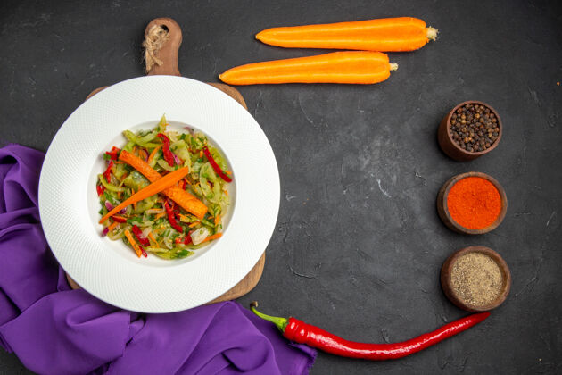 特写顶部特写查看切菜板上的蔬菜沙拉香料胡萝卜桌布膳食板盘子