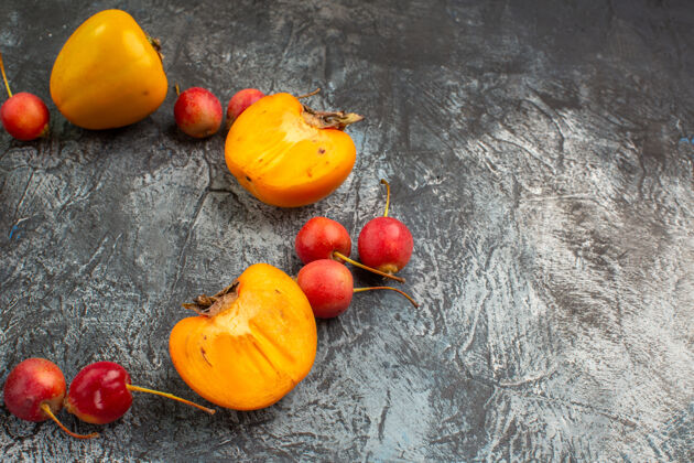 新鲜侧面特写：灰色桌子上开胃的樱桃半个柿子蔬菜秋季壁板