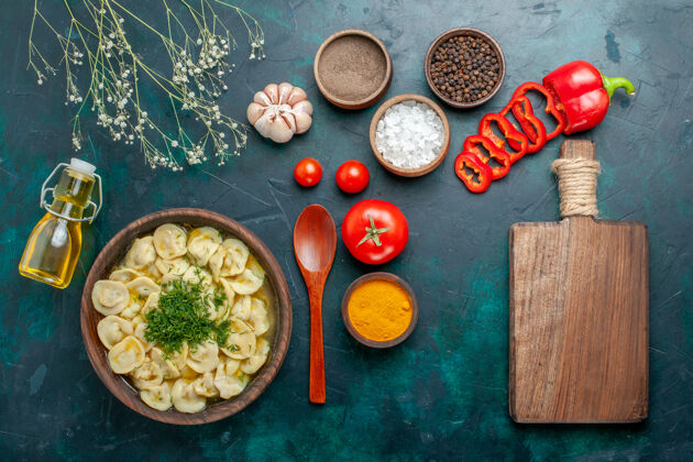 晚餐俯瞰美味的饺子汤 油调味料和西红柿放在绿油油的表面上 美食一餐汤肉午餐餐厅汤