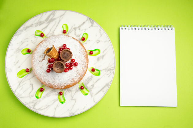 艺术从远处俯瞰一个蛋糕一个有华夫饼浆果的蛋糕白色笔记本围兜节日卡通