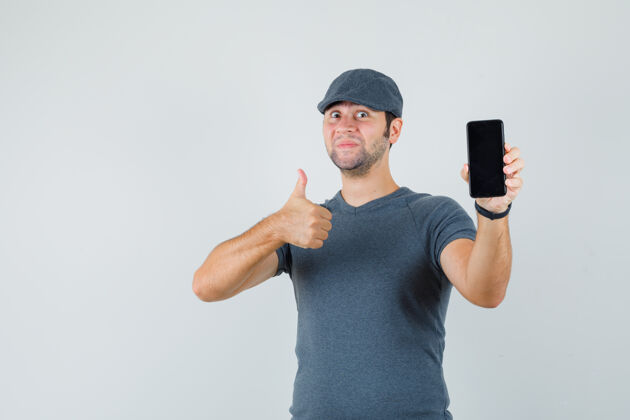 商务网络摄像头戴着t恤帽的年轻男子举着手机竖起大拇指远视小儿童