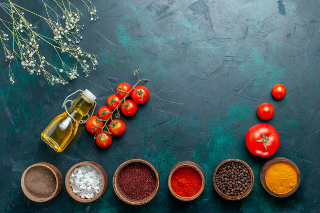 新鲜顶视图不同的调味品 以番茄和油为背景 深绿色 辛辣的食物原料西红柿深绿色