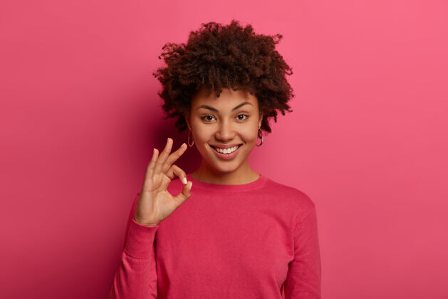 姿势满意的非裔美国妇女的画像显示良好的姿态 说优秀 宣布好消息 喜欢产品和保证最好的质量 微笑积极 给出建议和喜欢的选择随意非洲同意