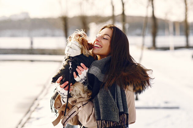 品种可爱的女孩和她的狗在冬季公园散步肖像森林冬天