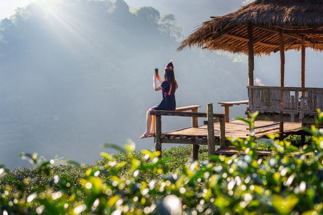 清朝一个穿着山地部落服装的女人坐在绿茶田的小屋里篮子部落越南