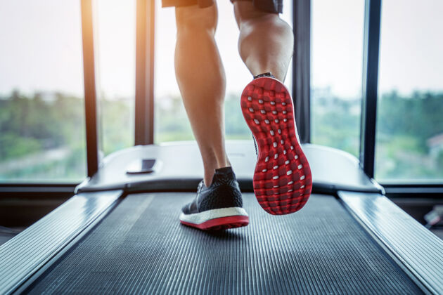 腿部穿着运动鞋在健身房跑步机上跑步的男性脚运动概念运动服运动员活跃