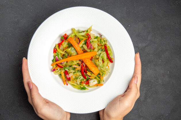 手顶部特写视图沙拉盘的开胃沙拉与蔬菜在手一餐食物晚餐