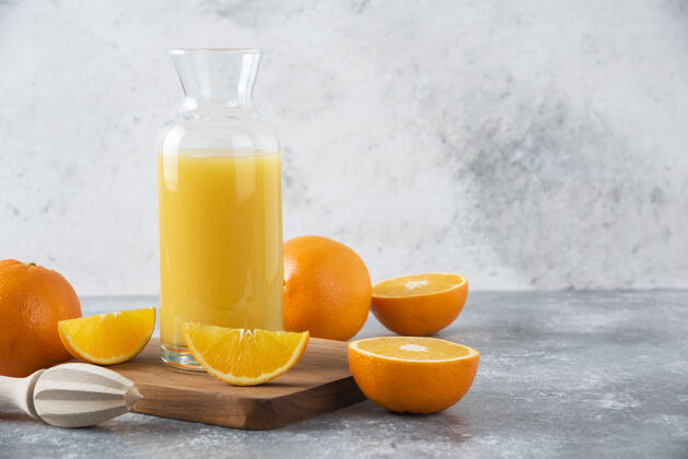 圆形一个装着新鲜橙子的果汁的玻璃罐放在木板上热带味道甜点