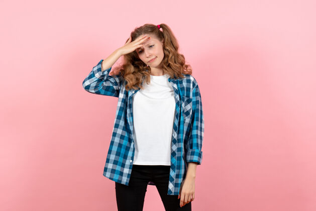 漂亮正面图身着蓝色格子衬衫的年轻女性在粉色背景上摆姿势的女性儿童青年模特色彩感慨年轻女性衬衫围巾