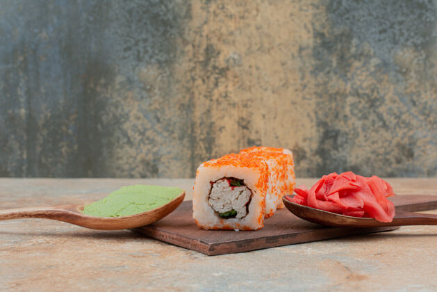 米饭一套美味的寿司卷 汤匙和酱油放在大理石上卷海食物