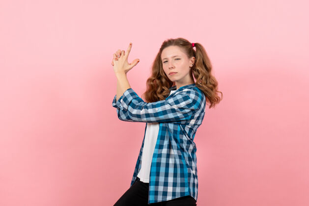 孩子正面图：穿着格子衬衫的年轻女性在粉色背景上摆姿势 女性儿童青少年色彩情感模型姿势漂亮头发