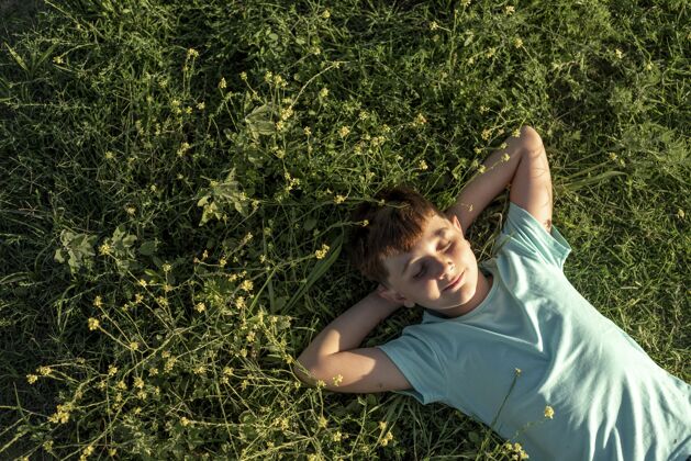 年轻中枪小子躺在草地上表情男孩青春