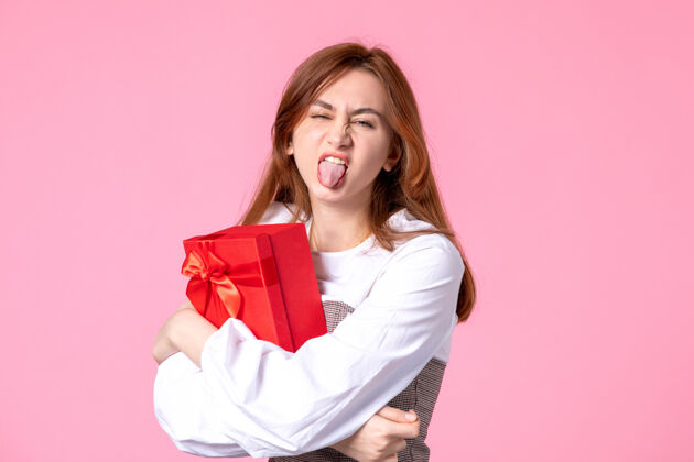 包装正面图：年轻女性以红色包装呈现在粉色背景上日期：三月水平女性性感平等香水年轻女性礼品