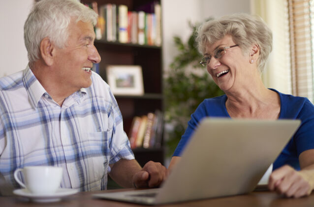 网络快乐的老年夫妇使用他们的笔记本电脑老年夫妇活力女人