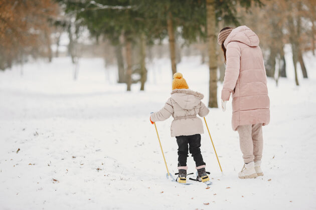 小小女孩和妈妈一起越野滑雪运动员滑雪年轻