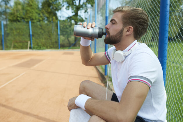 网球玩家在喝水水瓶球员休息