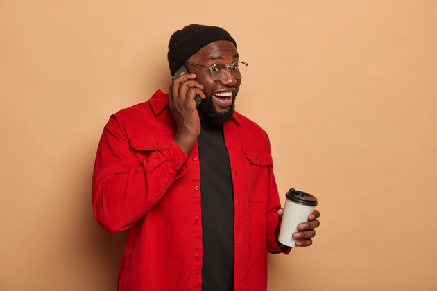 民族快乐的黑皮肤男人打电话 喝外卖咖啡的侧影手机室内非洲