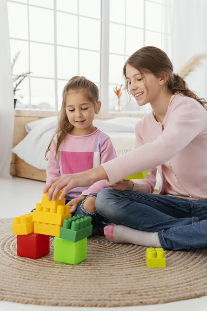 团结两姐妹在家玩玩具的正面图家庭乐趣一起