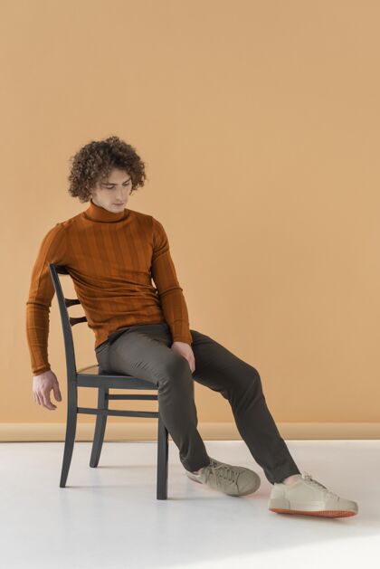 姿势卷发男人穿着棕色衬衫在椅子上摆姿势男性帅气模特