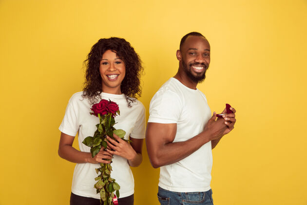 浪漫决定情人节庆祝 快乐的非洲裔美国夫妇隔离在黄色的墙上人类情感的概念 面部表情 爱情 关系 浪漫的节日女人快乐情人节