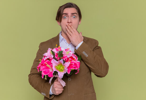 日年轻人拿着一束鲜花看着摄像机 捂着嘴大为震惊男人花花束