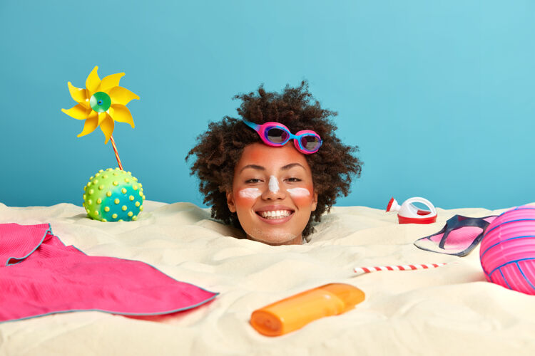 海滩年轻女子头上涂着防晒霜 脸上围着沙滩饰品海洋活力假日