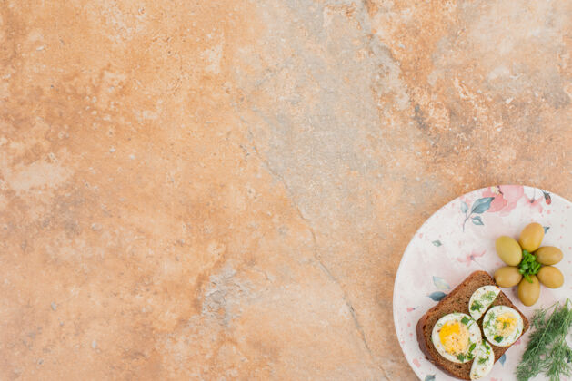 小吃在大理石桌上烤熟鸡蛋大理石桌子面包绿色
