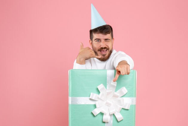 笔记本电脑正面图：年轻男性站在粉色圣诞照片情感睡衣派对礼品盒内展台礼物成人