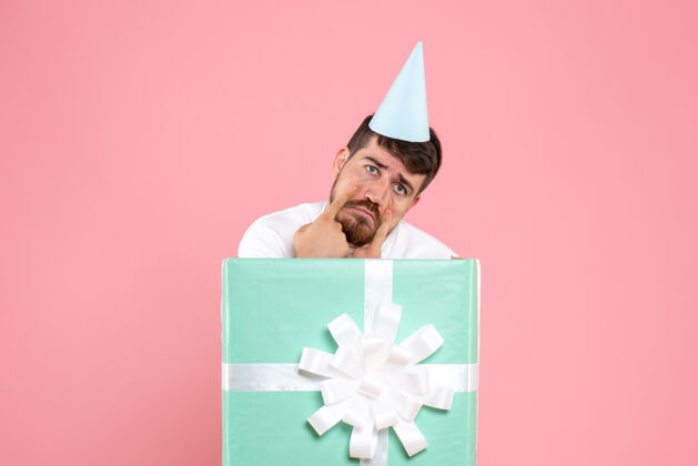 庆祝正面图：年轻男性站在礼物盒内 粉色情感圣诞照片鞠躬礼物里面