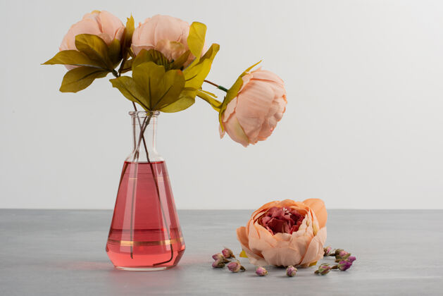 花粉红色的牡丹花 放在灰色桌子上的玻璃花瓶里束花花
