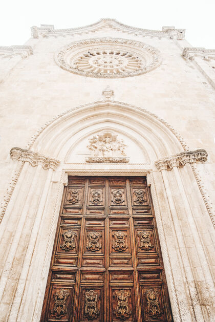 意大利白色混凝土建筑上的棕色木门景色对称教堂