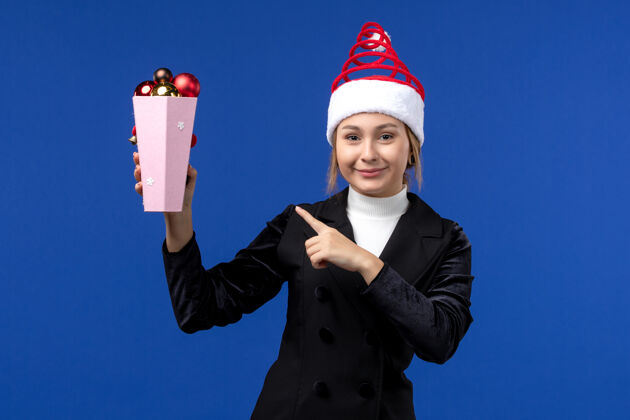 西装前视图美丽的女性手持塑料树玩具在蓝色的墙壁蓝色的新年假期人玩具专业
