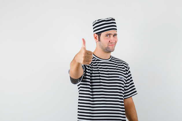 成年人年轻的男性穿着t恤 戴着帽子 竖起大拇指 看起来很自信 正前方的景色男性头发肌肉