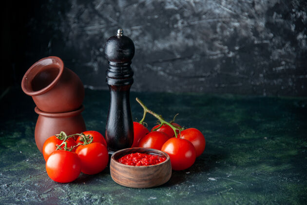 番茄正面是番茄酱 新鲜的红色番茄放在深色的表面上 番茄红色 调味料 胡椒盐蔬菜调味品颜色