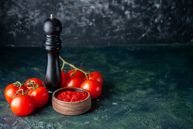 胡椒前视图番茄酱与新鲜的红色番茄在黑暗的表面红色调味料胡椒盐颜色观点番茄