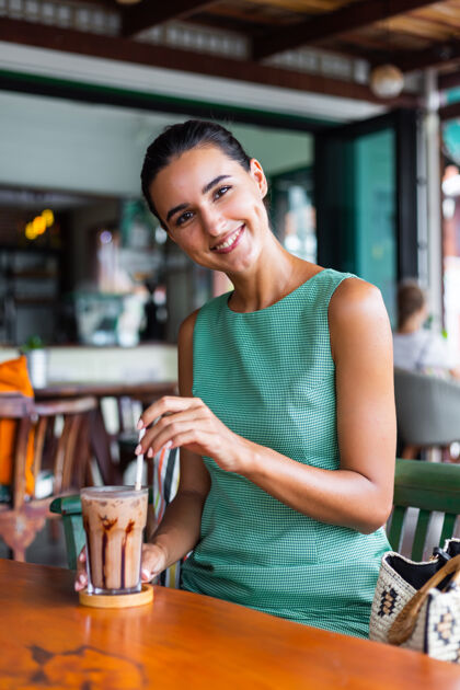 咖啡可爱 优雅 平静 快乐的女士 穿着绿色夏装 坐在咖啡馆里喝咖啡 享受早晨一年轻餐桌