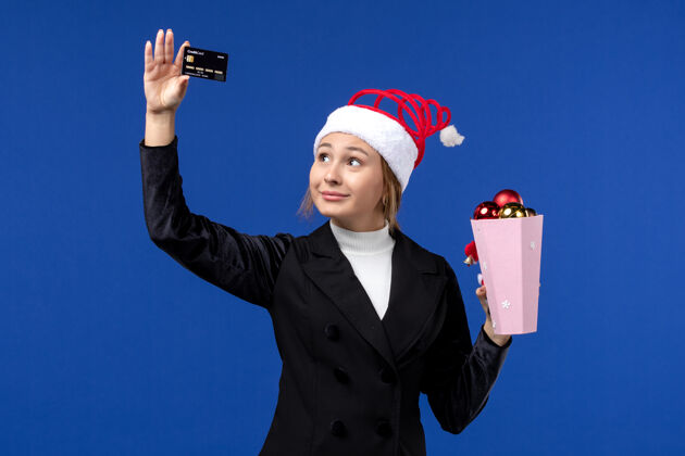 职业正面图年轻女士拿着银行卡在蓝墙玩具新年情感假期商人银行人