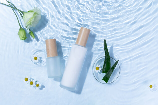 产品浅蓝色水面上的芦荟和雏菊花护肤瓶俯视图收集容器波纹