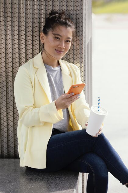 科技年轻女子在户外享受一杯咖啡女性肖像自然