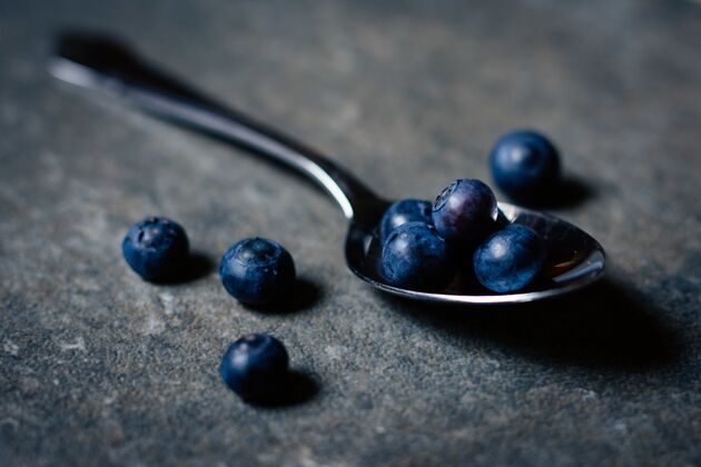 碗木桌上新鲜有机蓝莓银勺特写镜头水果新鲜素食