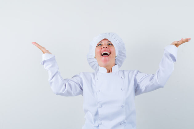 提高一位身穿白色制服的女厨师抬起手掌 看上去很开心欢呼时尚乐趣