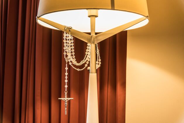 设计床头灯的垂直镜头 上面挂着一个银十字架 在灯光下闪闪发光颜色灯