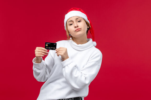 女士正面图红色背景上手持银行卡的年轻女性银行正面肖像