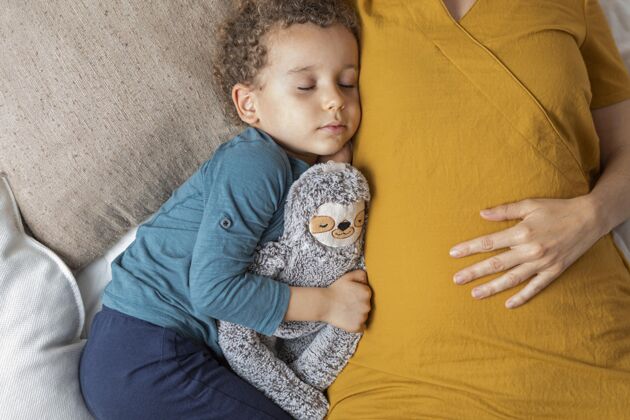 年轻人睡在他妈妈旁边的小男孩模特妈妈儿子