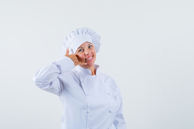 时尚一位身穿白色制服的女厨师展示着打电话的姿势 看上去很乐观模特乐观看起来
