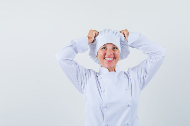 看一位身穿白色制服的女厨师手把手放在头上 看上去很开心信心制服举行