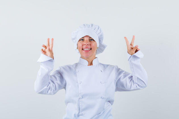 制服一个金发女人 双手举着和平的标志 穿着白色厨师制服 看起来很漂亮皮肤自然人